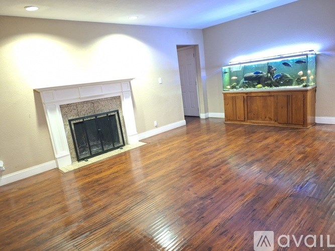 A room with a fireplace and a fish tank.