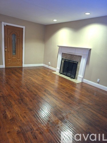 A room with a wooden floor and a fireplace.