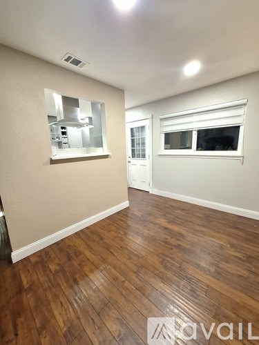 A room with wooden floors and a mirror on the wall.