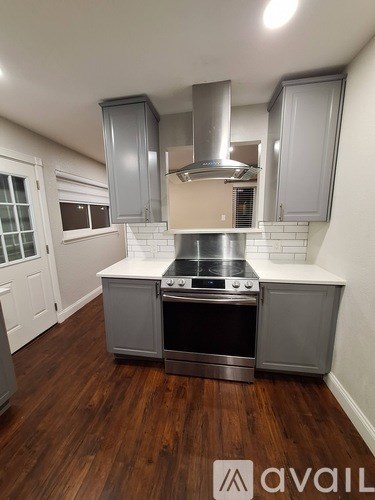 A kitchen with a stove top oven and a range hood.