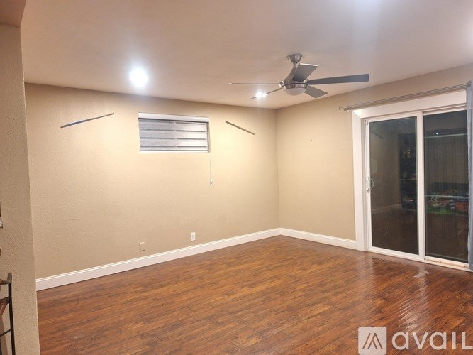 A room with a ceiling fan and a window with blinds.
