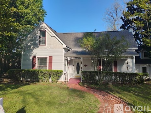 A house with a red brick walkway leading to the front door.