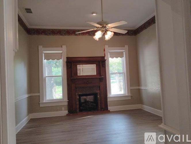 A room with a fireplace and a ceiling fan.