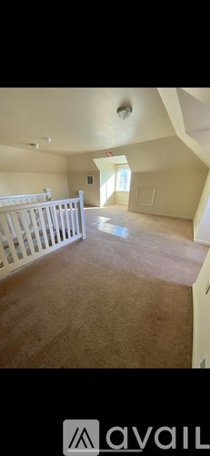A room with a carpeted floor and a white railing.