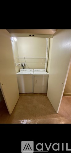 A small, empty room with two beds and a white door.