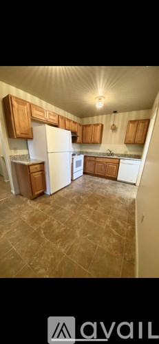 A kitchen with wooden cabinets and a white refrigerator.