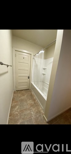 A bathroom with a tiled floor and a white door.