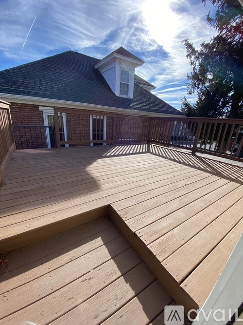 A wooden deck with a house in the background.