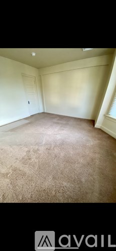 A room with beige carpet and white walls.