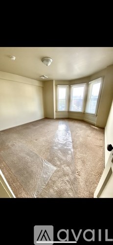 A room with a carpeted floor and a window.