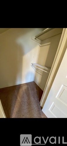 A hallway with a carpeted floor and white walls.