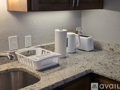 A kitchen counter with a sink, toaster, and paper towels.