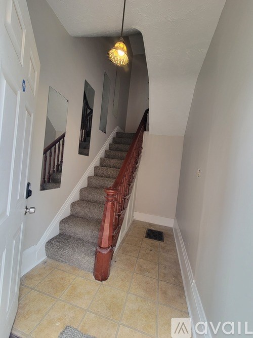 A hallway with a staircase and a door.
