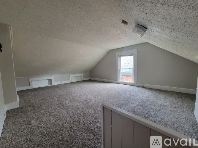 A room with a carpeted floor and a window letting in natural light.