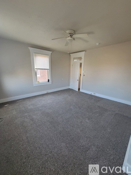 A room with a ceiling fan and carpeted floor.