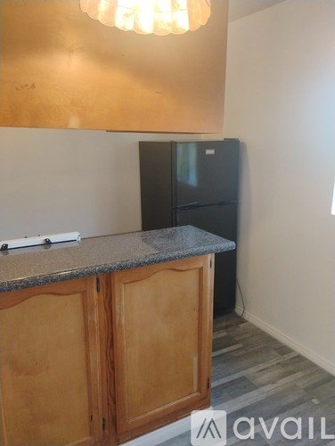 A kitchen with a granite countertop and wooden cabinets.