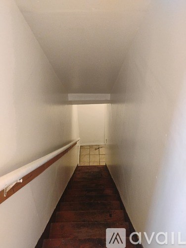 A long hallway with a wooden floor and white walls.