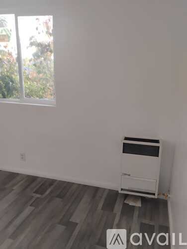 A room with a window and a wall-mounted air conditioner.