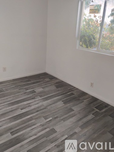 A room with a wooden floor and a window.