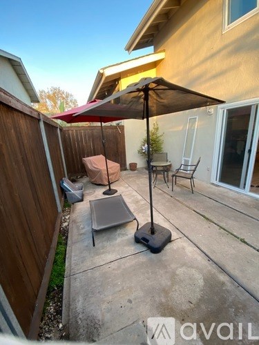 A patio with a table and chairs under an umbrella.