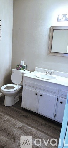 A white toilet sits next to a white sink in a bathroom.