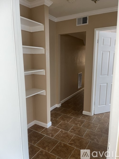 A white pantry with a white door and brown walls.