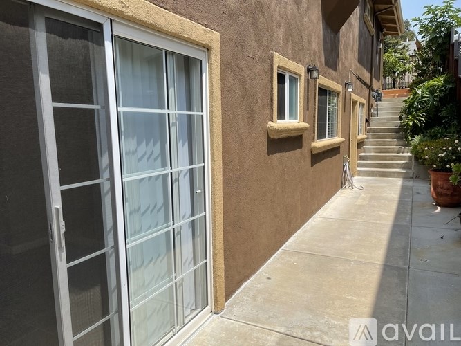 A house with a glass door and a staircase leading to the front door.