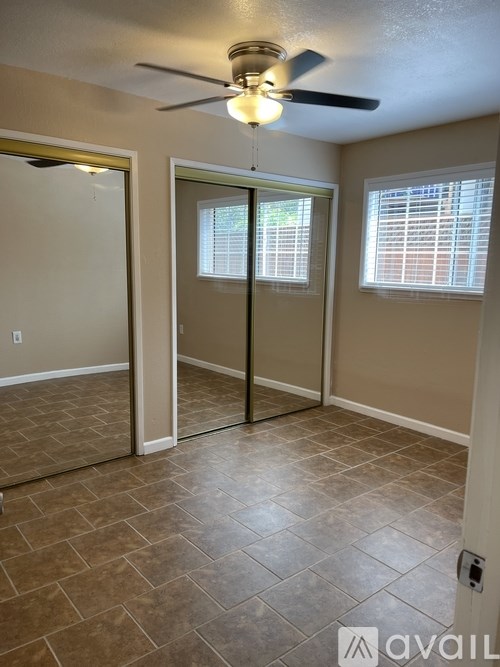 A room with a ceiling fan and tiled flooring.