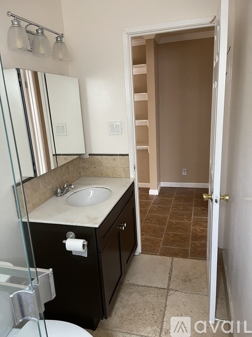 A bathroom with a sink, mirror, and toilet.