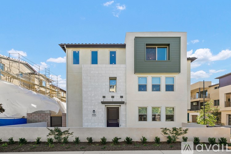 A modern house with a white facade and blue windows.