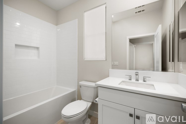 A white bathroom with a toilet, sink, and bathtub.
