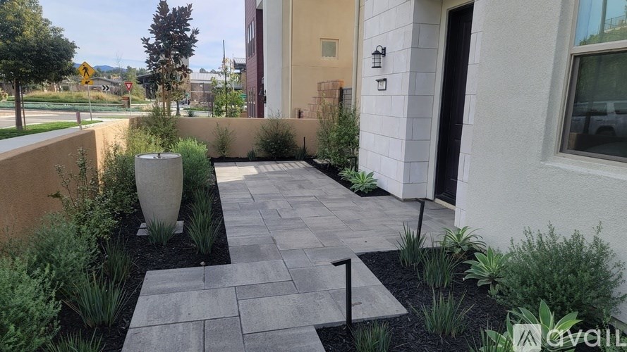 A garden with a stone pathway and a large planter.