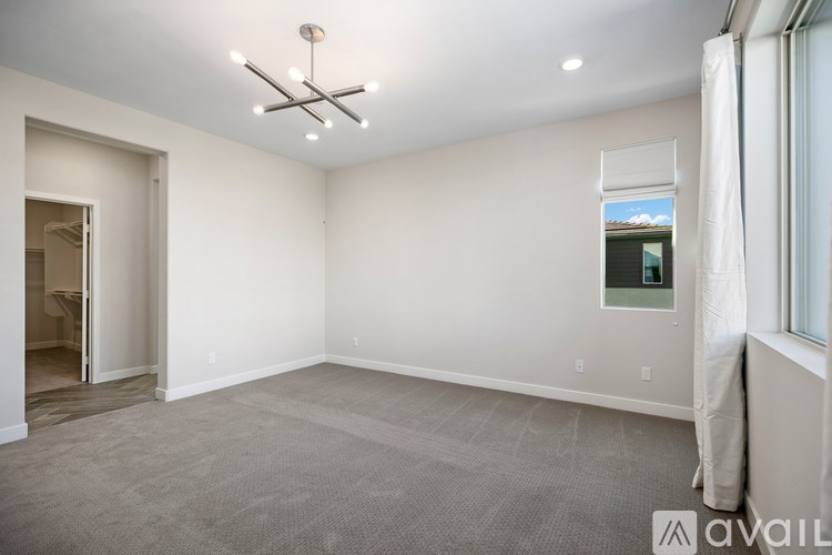 A spacious room with a grey carpet and a ceiling light.
