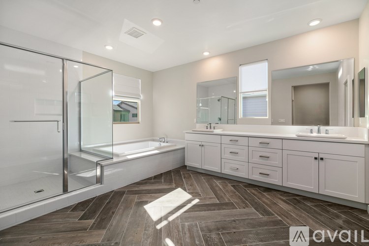 A bathroom with a walk-in shower and double sinks.