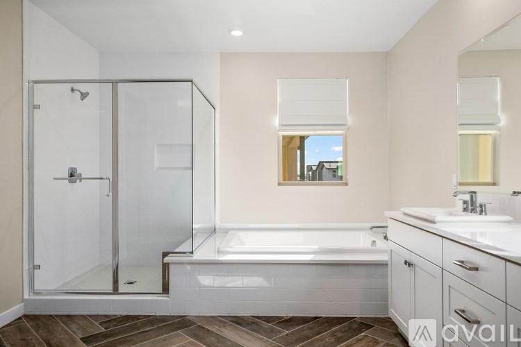 A bathroom with a glass shower door and a white bathtub.