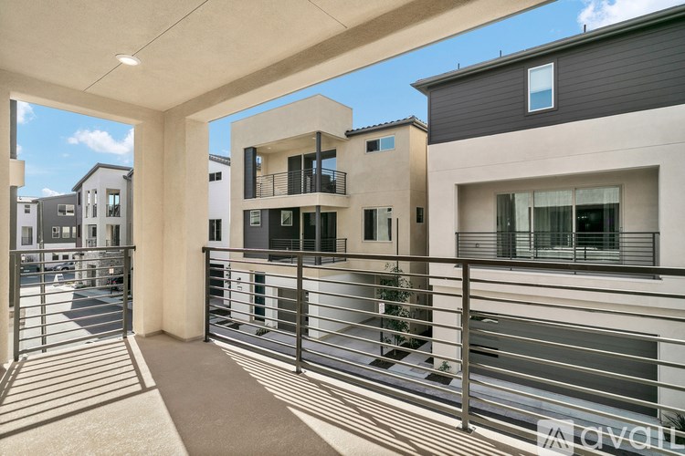 A modern balcony with a metal railing and a beige carpet.