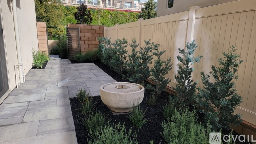 A garden with a stone pathway and a large stone pot.