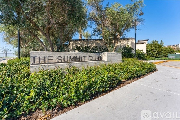The Summit Club sign is surrounded by green shrubbery.