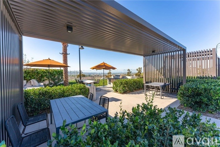 A patio with a table and chairs under a roof.