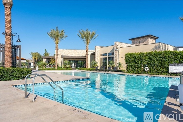 A pool with a slide and a building behind it.
