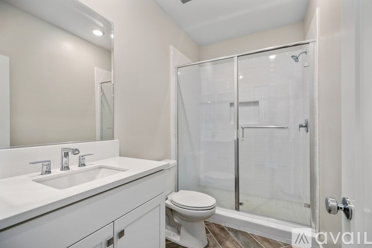 A white bathroom with a glass shower door.