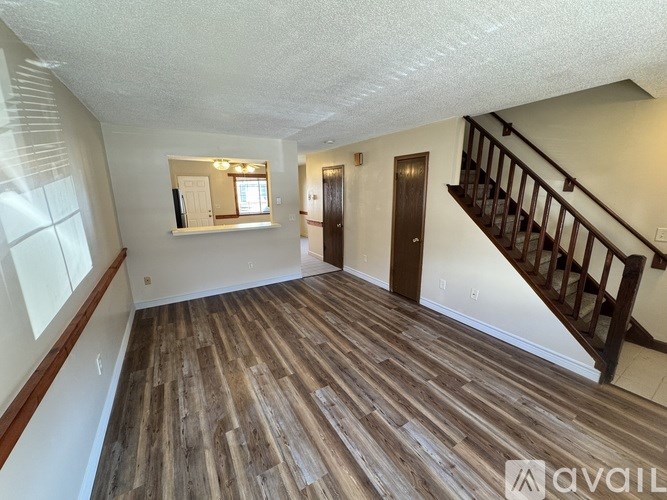 A room with wooden flooring and a staircase.