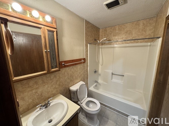 A bathroom with a toilet, sink, and shower.