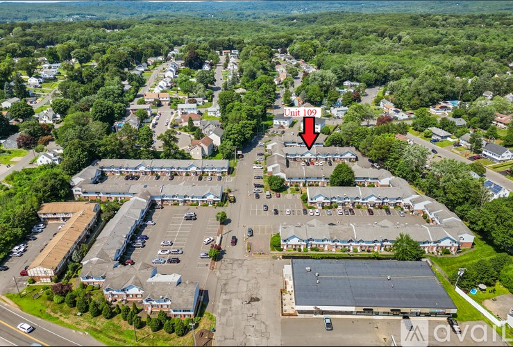 An aerial view of a parking lot with a red arrow pointing to a specific area.
