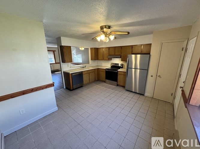 A kitchen with a refrigerator, sink, and cabinets.