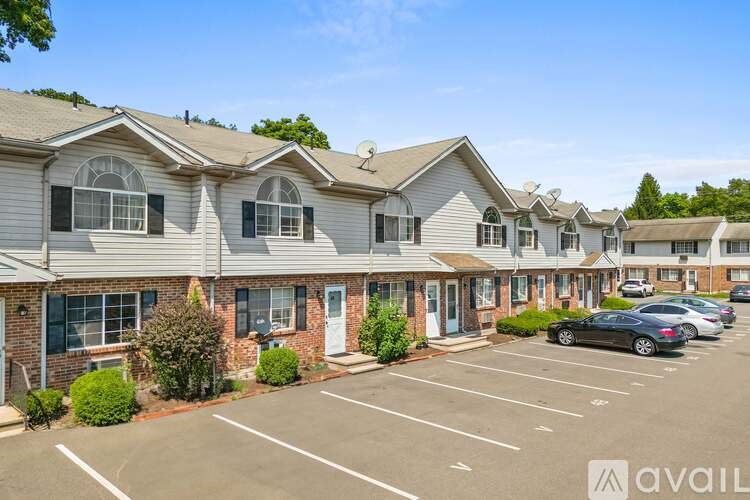 A row of houses with a car parked in the parking lot.