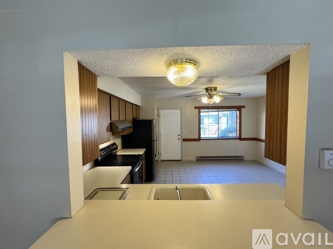 A kitchen with a sink, stove, and refrigerator.