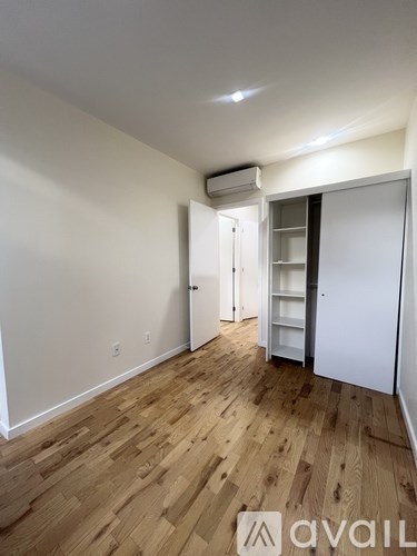 A room with wooden flooring and a white door.