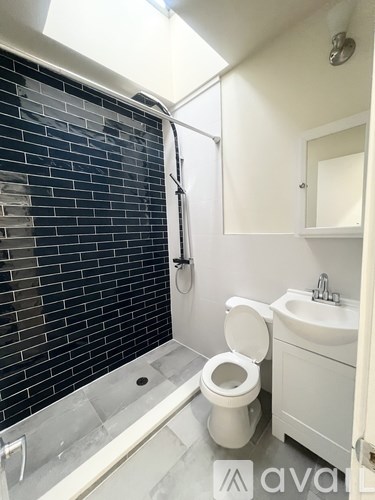 A bathroom with a toilet, sink, and a glass shower door.