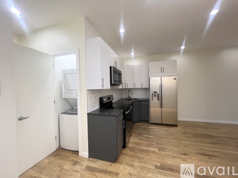 A kitchen with wooden floors and white walls.